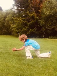 Side view of boy playing on field