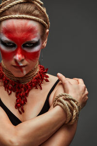 Close-up of woman with face paint against black background
