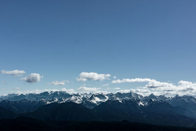 Scenic view of mountains against blue sky