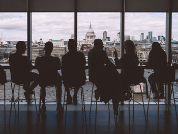 Silhouette of people in front of building