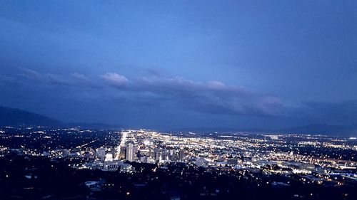 Aerial view of illuminated cityscape against sky at night
