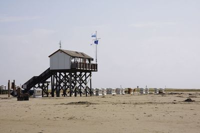 Lifeguard hut on beach against sky