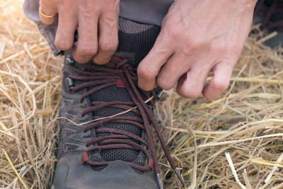 Midsection of man holding hands on field