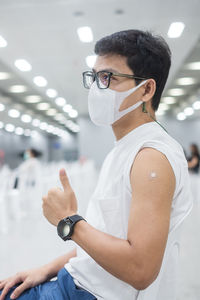 Full length portrait of young man standing against wall