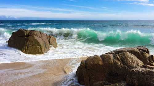 Scenic view of rocks in sea against sky