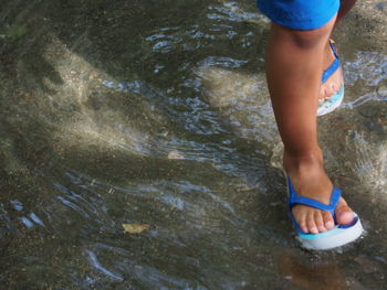 Low section of kid standing in water