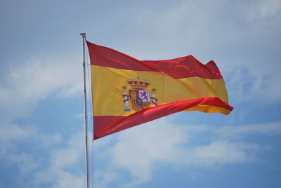 Low angle view of flags waving against sky