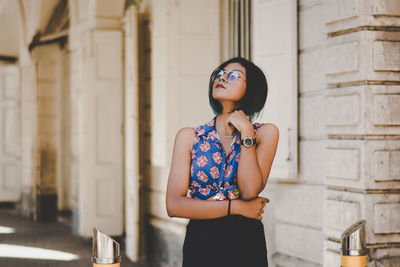 Full length of woman standing against wall