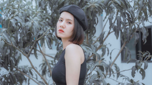 Close-up portrait of young woman by tree