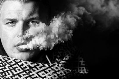 Close-up portrait of young man smoking outdoors