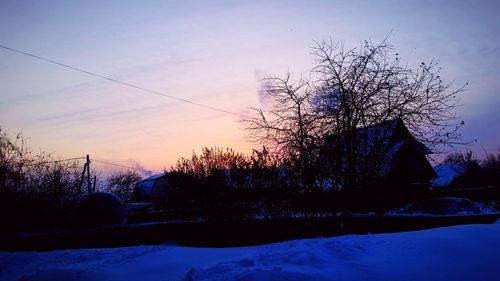 Silhouette trees against sky during winter