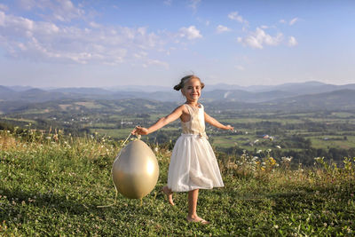 Woman standing on field against sky