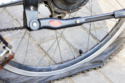 A punctured and flat bicycle tire on a background of gray paving slabs. closeup.