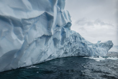 Scenic view of iceberg in sea against sky