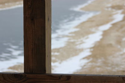 Close-up of snow on wood against sky