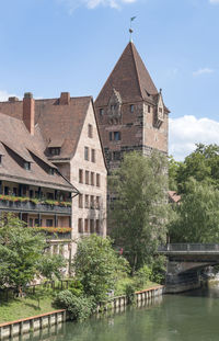 Trees by historic building against sky