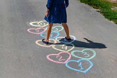 Low section of woman walking on road