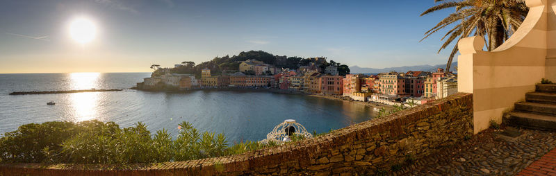 Panoramic view of sea and buildings against sky during sunset