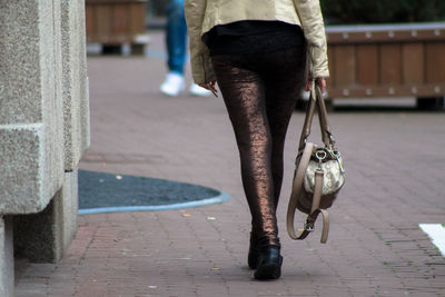 Low section of woman standing on street