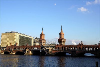 Oberbaumbrucke over river against sky in city on sunny day