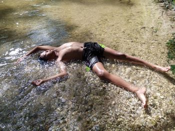 Low section of man swimming in lake