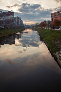 River amidst buildings in city against sky