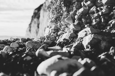 Close-up of pebbles on beach against sky