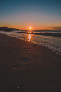 Scenic view of beach against sky during sunset