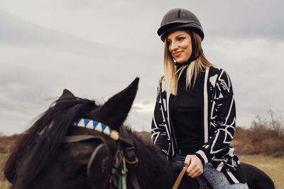 Young woman riding horse