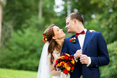 Bride and groom standing at park