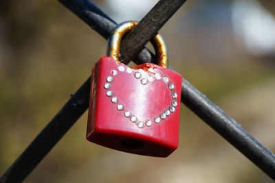 Close-up of red padlock on fence