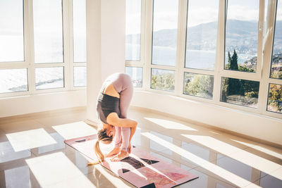 Side view of woman exercising at home