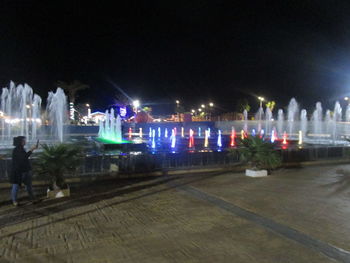 Illuminated city against sky at night