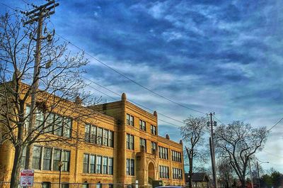 Low angle view of buildings against cloudy sky