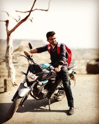 Young woman riding motorcycle against sky