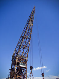 Low angle view of crane against blue sky