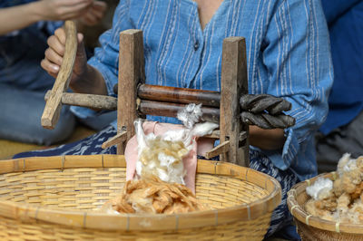 Man holding ice cream in basket on table