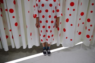 Low section of women standing on floor against curtain with polka dots