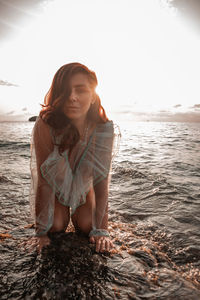 Woman smiling at beach against sky