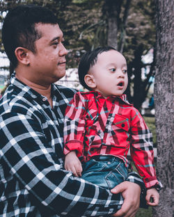 Father and daughter sitting outdoors