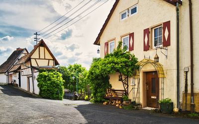 Footpath amidst houses against sky