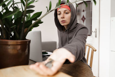 Portrait of young woman sitting on table