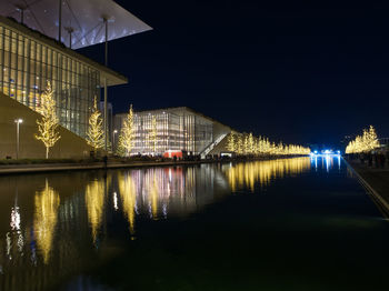 Illuminated bridge over river against sky at night