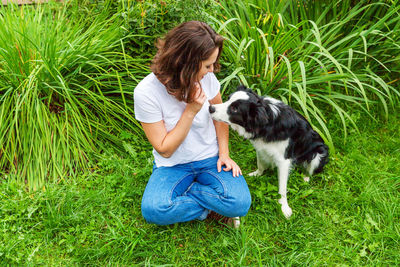 High angle view of woman with dog on grassy field