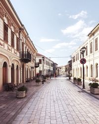 Street amidst buildings in town against sky