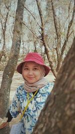 Portrait of smiling boy on tree trunk