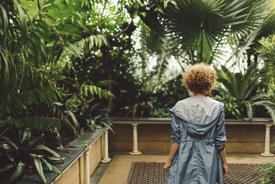 Rear view of young woman standing on footpath