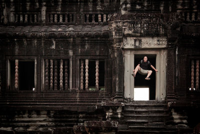 Man jumping at entrance of historic building