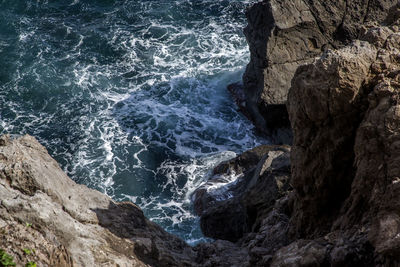 High angle view of sea by rock formations