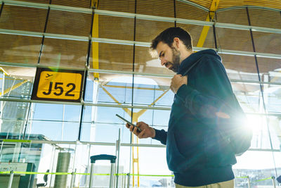 Low angle view of young man standing against building